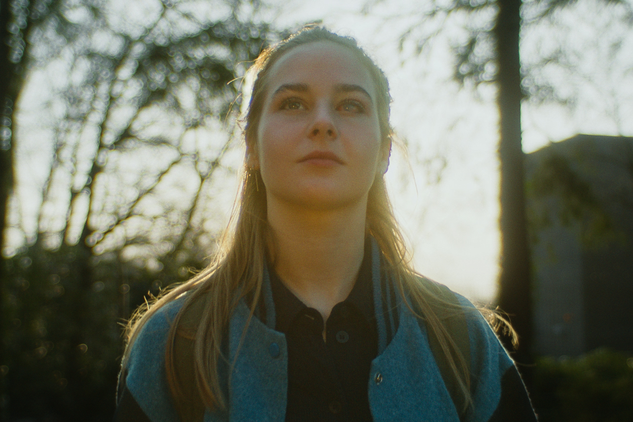 Een jonge vrouw met lang haar staart omhoog in het zonlicht